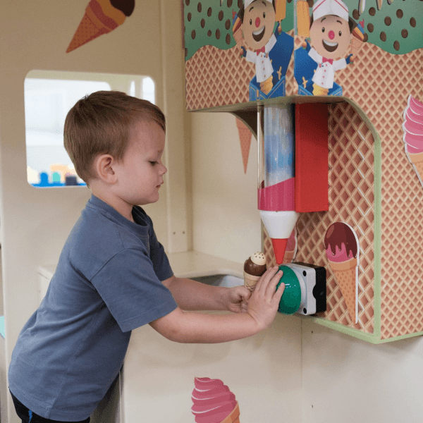 A little boy playing with the pretend ice cream set in the role-play area at Jack in the Box Club, enjoying a fun ice cream-making experience.