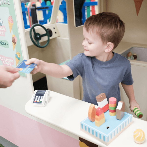 A little boy playing with the pretend ice cream set in the role-play area at Jack in the Box Club, enjoying a fun ice cream-making experience.